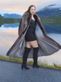 Model walking in open raccoon fur coat revealing satin lining, styled with black mini dress, luxury winter fashion apparel.