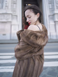 Close-up of vintage pastel Canadian brown mink fur coat draped off shoulder, highlighting luxurious texture and feminine silhouette.