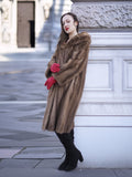 Model leaning against stone wall in vintage pastel Canadian brown mink fur coat, ideal for luxury outerwear and timeless fashion appeal.