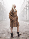 Side view of classic pastel brown mink fur coat stroller jacket M/L with hands in pockets. Elegant and cozy winter outerwear.