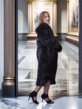 Woman wearing a black fur coat in an elegant interior setting
