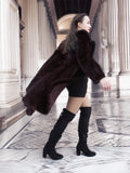 Side view of La Galleria mahogany mink fur coat in motion, showcasing its full-length cut and flowing satin lining for dynamic winter fashion.
