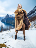 Woman in vintage red fox coat on snowy hill