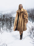 Woman in vintage red fox coat on snowy path