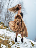 Model twirling in vintage red fox coat on snowy hill