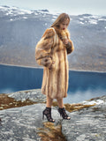 Woman in vintage red fox coat on rocky terrain