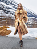 Woman wearing vintage red fox coat on a snowy path