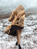 Back view of vintage red fox coat in snowy field