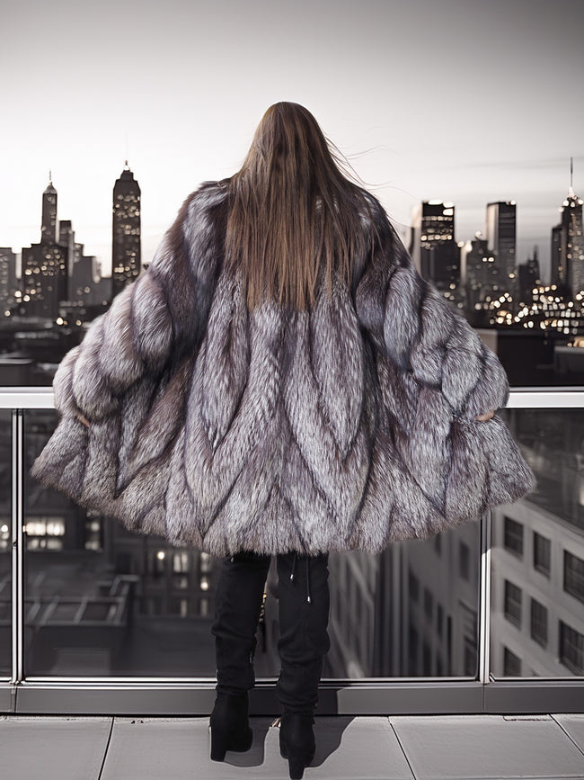 Person wearing a fur coat standing on a rooftop with city skyline view