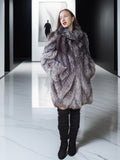 Woman wearing a fur coat on a reflective floor with a blurred background