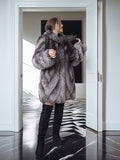 Person wearing a fur coat in a modern interior setting