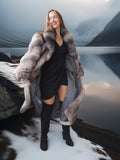 Woman in a fur coat and black dress standing next to a car with a mountainous background