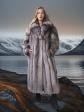 Woman wearing a fur coat standing in front of a scenic mountain landscape.