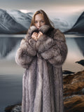 Person wearing a long fur coat with a mountainous background