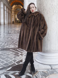 Model leaning against a column wearing Brand New Luxurious Demi Buff Swing Canadian Mink Fur Coat L/XL, showcasing relaxed elegance.