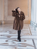 Model posing in Brand New Luxurious Demi Buff Swing Canadian Mink Fur Coat L/XL, styled with black boots in a marble corridor.