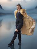 Woman in a long fur coat standing on a reflective surface with mountains in the background