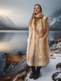 Person wearing a fur coat standing in a snowy landscape with mountains in the background
