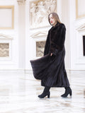 Black mink coat sways elegantly in a white marble hall, showcasing premium craftsmanship and winter luxury fashion.