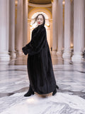 Black mink coat flows gracefully in a marble hall, capturing the essence of opulent winter fashion and timeless fur apparel.