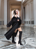 Model reveals black mini outfit under flowing mink coat, blending bold fashion with the warmth of real fur outerwear.