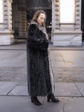 Side profile of black mink coat with indigo fox trim, styled for a sleek and warm winter look in L/XL sizing.