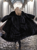Back view of black mink coat with indigo fox collar, showcasing voluminous silhouette and premium fur quality for cold-weather elegance.