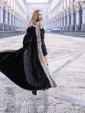 Dynamic spin in black mink coat with silver fox trim, highlighting the coat's volume and elegant lining.