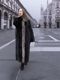 Elegant black mink coat with silver fox trim, worn in a foggy cityscape for a sophisticated winter outerwear look.