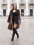 Vintage mink fur coat with open front, revealing satin lining and styled with a black mini dress for chic winter wear.