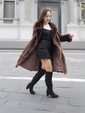 Elegant vintage mink fur coat in rich brown tones, paired with a black mini dress and boots for a chic outerwear look.