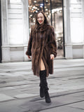 Woman walking in a luxurious dark mahogany mink fur coat, showcasing premium vintage outerwear for cold weather fashion.