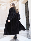 Back view of black mink fur coat in motion, highlighting its rich texture and volume. Elegant full-length outerwear, size M.