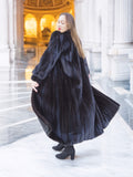 Luxury black mink fur coat with voluminous drape and soft sheen, twirling motion showcases full-length design. Premium winter outerwear, size M.