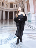 Model in black mink fur coat with one shoulder exposed, styled in a grand rotunda. Full-length fur outerwear, size M.