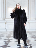 Elegant black mink fur coat with high collar and puffed sleeves, modeled in a neoclassical setting. Full-length luxury fur fashion, size M.