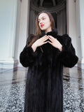 Model in black mink fur coat with hands raised, showcasing plush sleeves and elegant cut. Full-length winter coat, size M.