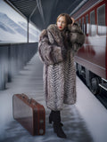 Woman in a fur coat with a suitcase on a train platform