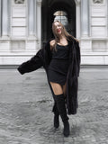 Chic black mink fur coat worn open over a black outfit, combining luxury fur fashion with modern street style.