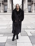 Elegant black mink fur coat with a structured collar and flowing hem, styled for sophisticated winter fashion.