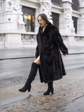Black mink fur coat in XL/XXL with a luxurious full-length design, worn with knee-high boots for a chic winter look on city streets.