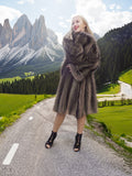 a woman in a fur coat standing on a road