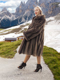 a woman in a fur coat standing on a path