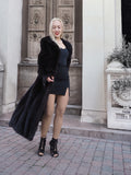 Elegant black fur coat showcased against ornate architectural backdrop, exuding luxury and sophistication.