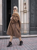 Luxurious vintage Canadian brown mink fur coat with stroller-length design, worn by fashionable woman in front of ornate architecture.