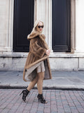 Stylish vintage Canadian brown mink fur coat and designer sunglasses on model posing outdoors against architectural backdrop.