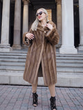 Elegant pastel brown mink fur coat with flowing silhouette, worn by a stylish woman in front of a historic building.