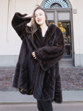 Close-up of XL/XXL mahogany mink coat with plush fur and wide sleeves. Premium cold-weather outerwear with gold baroque lining.