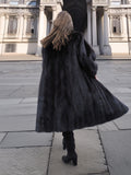 Back view of flowing black mink fur coat in motion, emphasizing luxurious volume and natural fur texture.