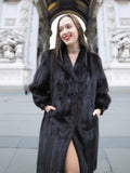 Smiling woman in black mink fur coat with front slit and wing collar, showcasing refined cold-weather fashion.